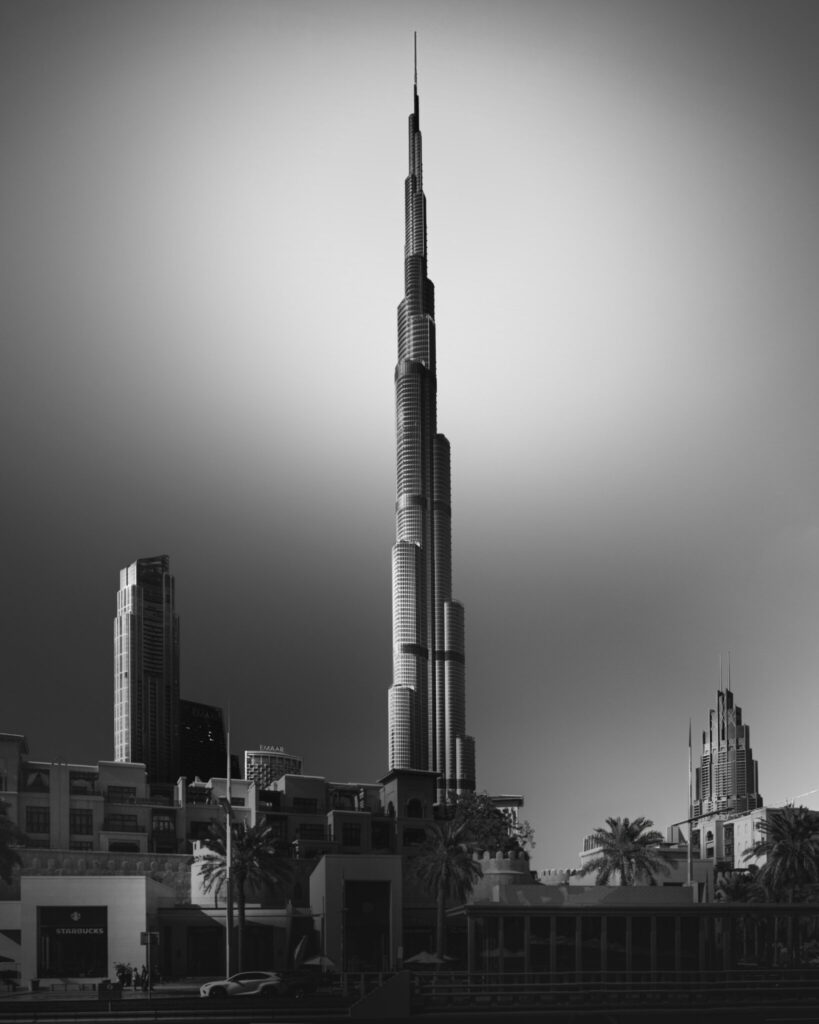Long exposure black and white fine art photograph of the Burj Khalifa isolated against a glowing sky above the Dubai skyline