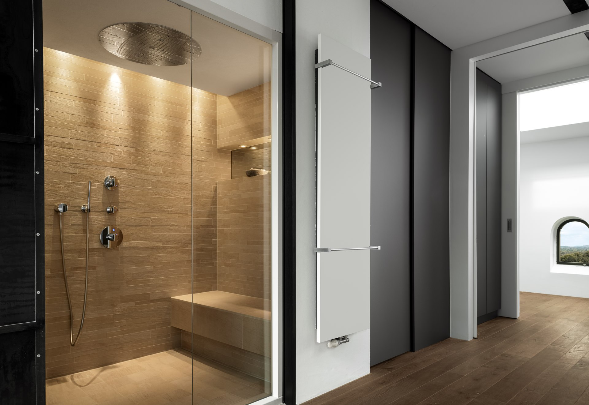Luxurious master bathroom with large walk-in rain shower, floor-to-ceiling stone tiles, and spa-style design