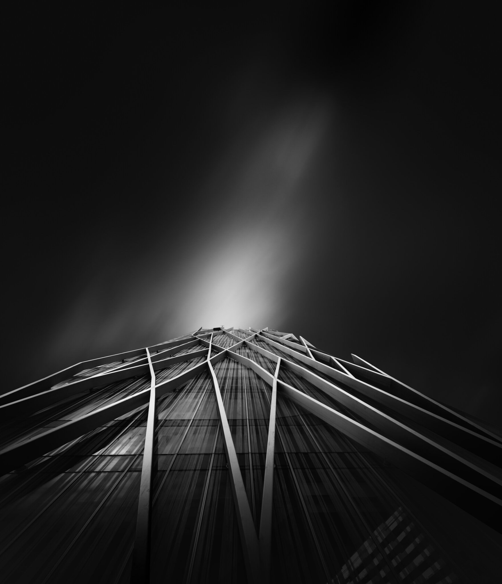 Low-angle black and white fine art photograph of intersecting glass building facades with bold diagonal geometry