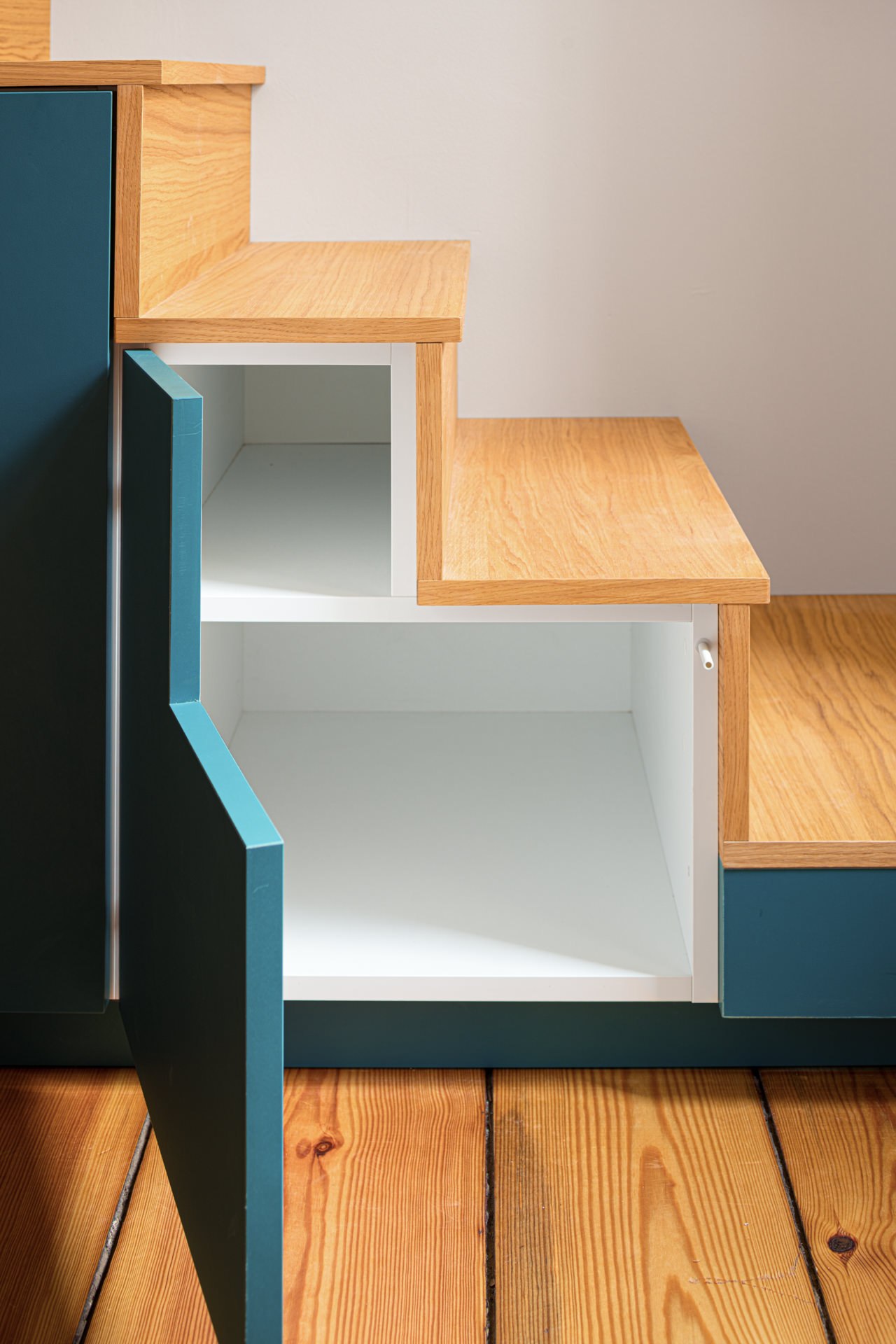 Architectural staircase detail with intersecting wood, white, and blue-painted surfaces — interior design photography