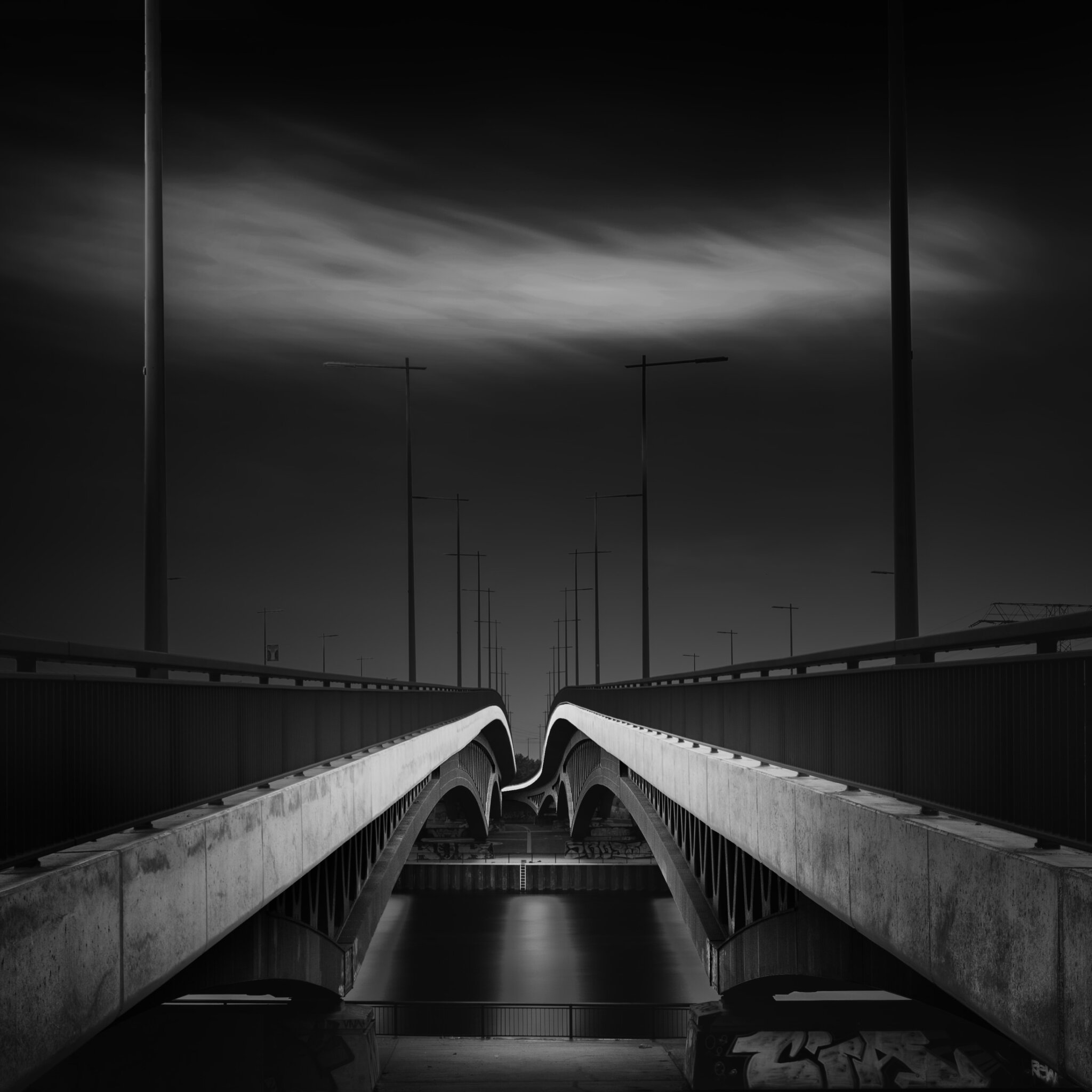 close-up black and white fine art photograph of a bridge against a pitch black sky